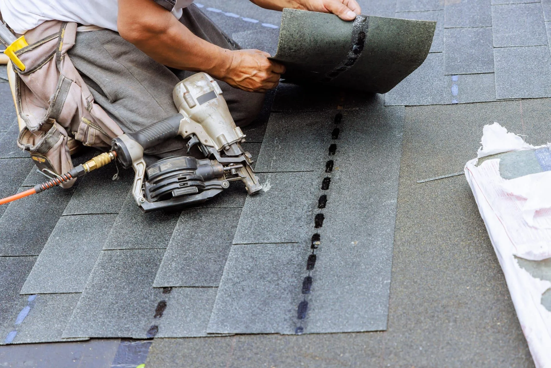 Roofer replacing damaged shingles during a targeted roof repair