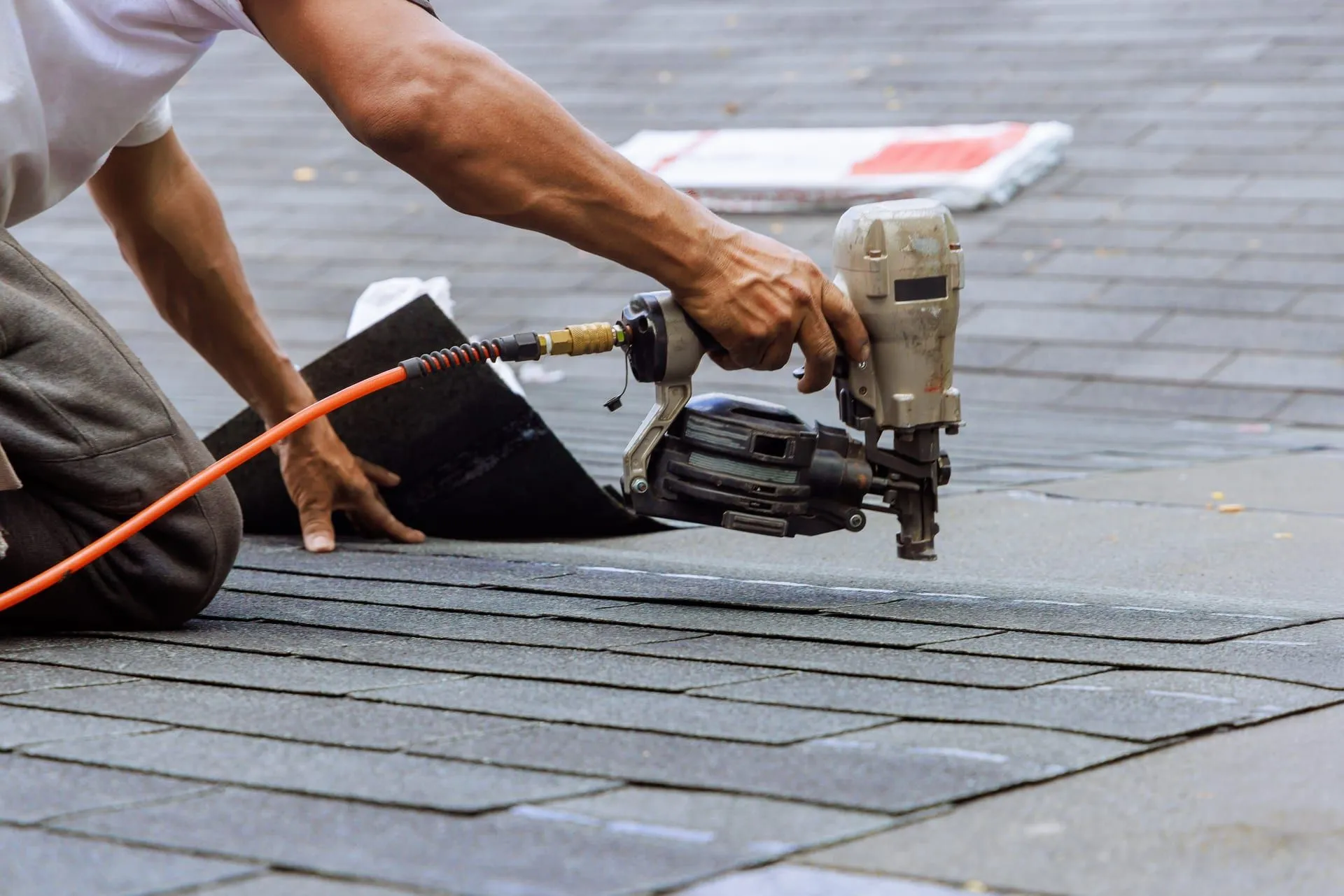 Crew installing architectural asphalt shingles on a residential roof